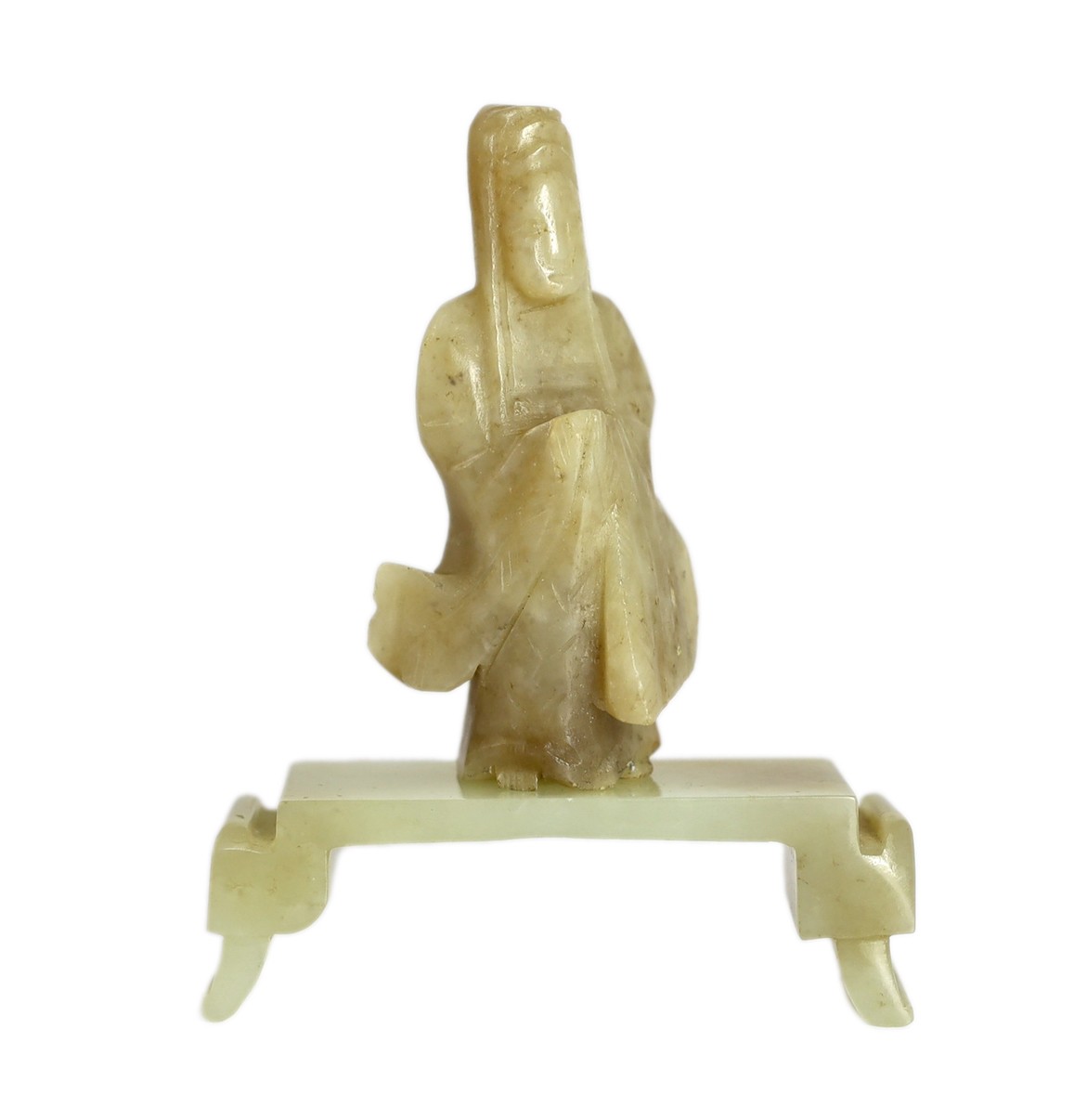 An early Chinese cream jade figure of Guanyin, together with a 19th century pale celadon and brown jade brushrest